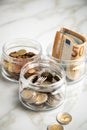 3 glass jars with Euro notes, 2Ã¢âÂ¬ coins and loose cash for housekeeping and savings Royalty Free Stock Photo